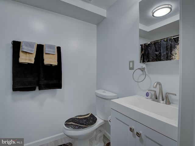 bathroom with vanity, toilet, and wood-type flooring