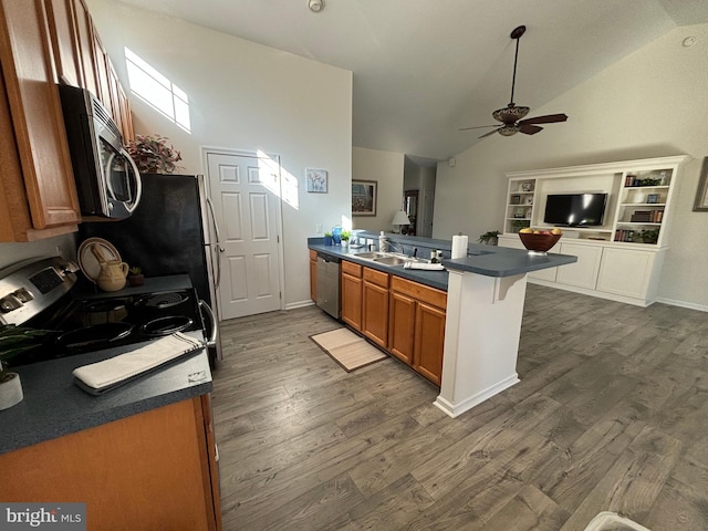 kitchen featuring vaulted ceiling, ceiling fan, dark hardwood / wood-style flooring, kitchen peninsula, and stainless steel appliances