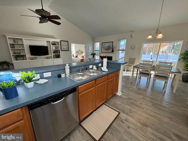 kitchen featuring hardwood / wood-style floors, lofted ceiling, ceiling fan with notable chandelier, sink, and stainless steel dishwasher