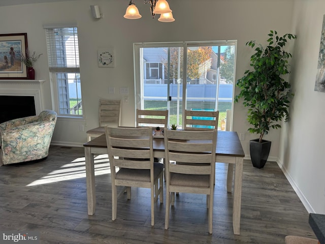 dining space with dark hardwood / wood-style flooring, an inviting chandelier, and a healthy amount of sunlight