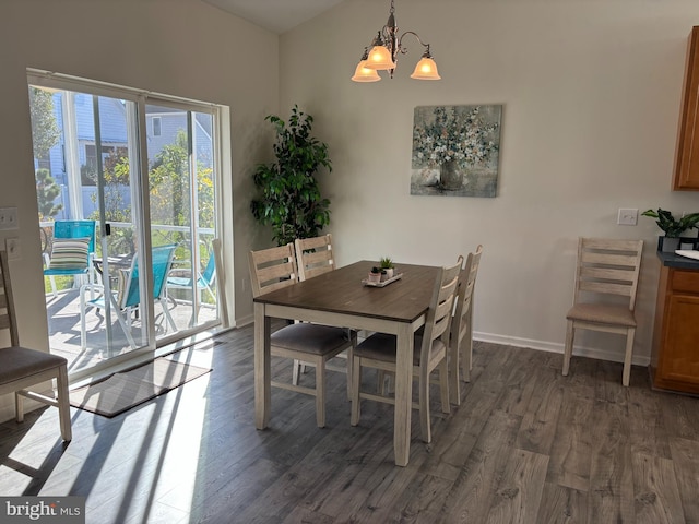 dining room with dark hardwood / wood-style flooring and a chandelier