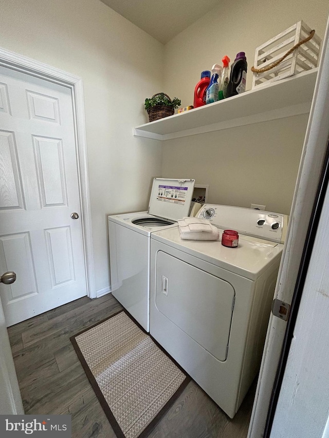 clothes washing area featuring washing machine and dryer and dark hardwood / wood-style flooring