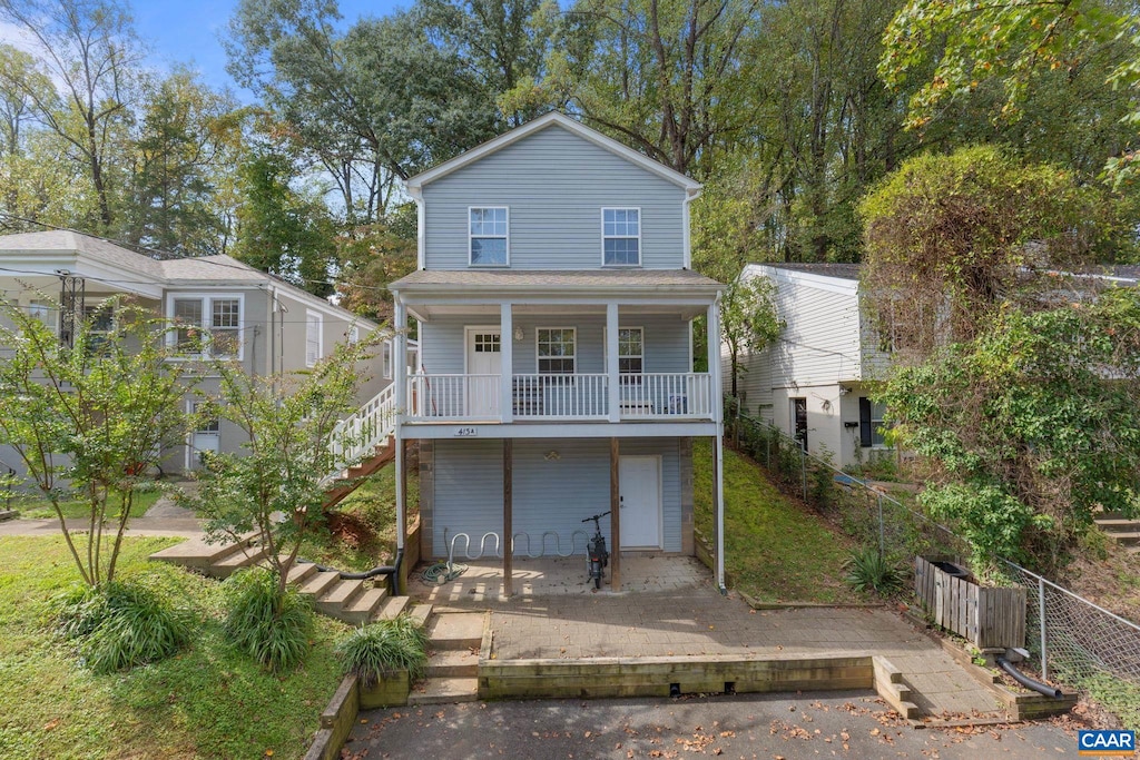 rear view of house featuring a garage and a porch