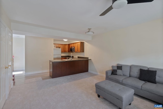 carpeted living room with ceiling fan and sink