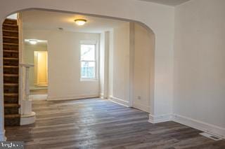 unfurnished room with dark wood-type flooring