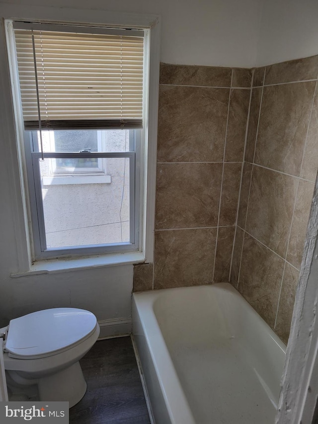 bathroom featuring a bathtub, hardwood / wood-style flooring, and toilet