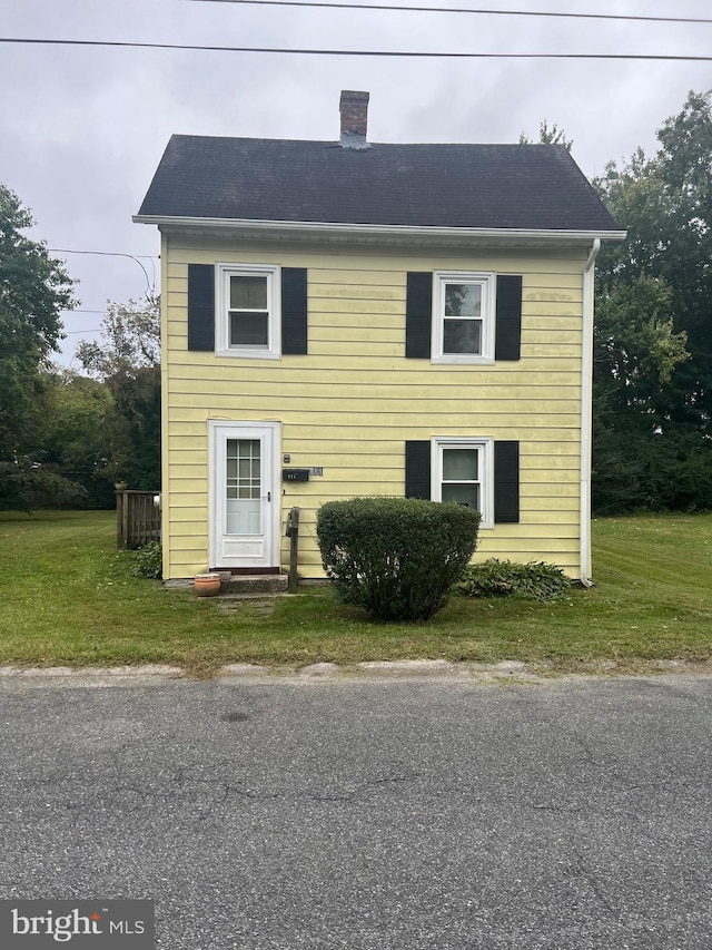 711 6th St, Pocomoke City, MD 21851 - colonial inspired home featuring a front yard, a chimney, and roof with shingles