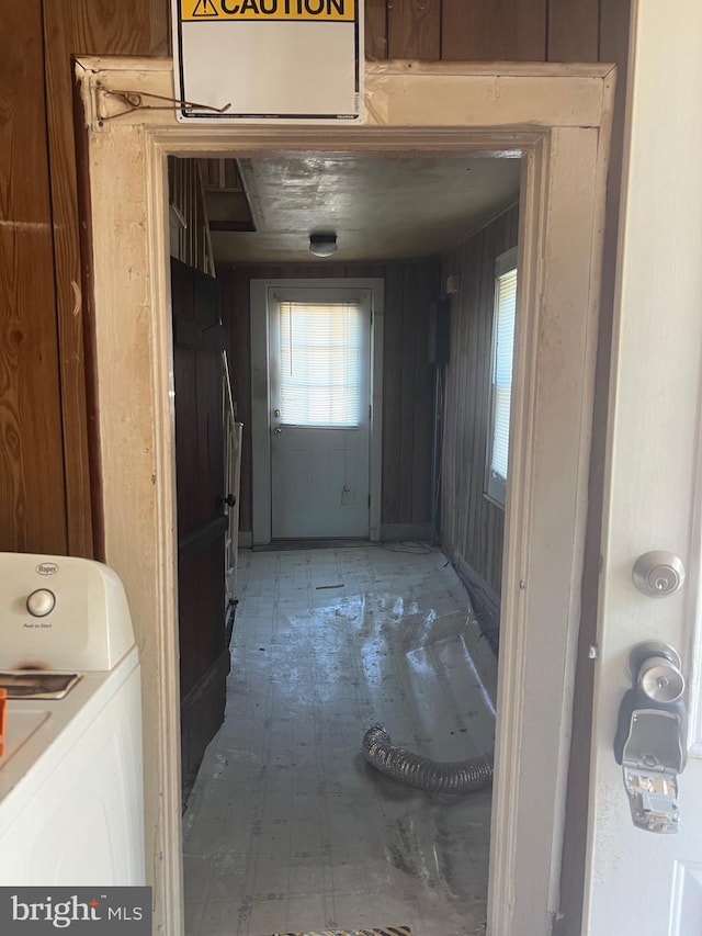 interior space featuring washer / clothes dryer and wood walls