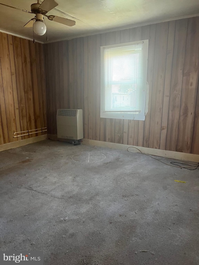 711 6th St, Pocomoke City, MD 21851 - spare room with wood walls, heating unit, and a ceiling fan