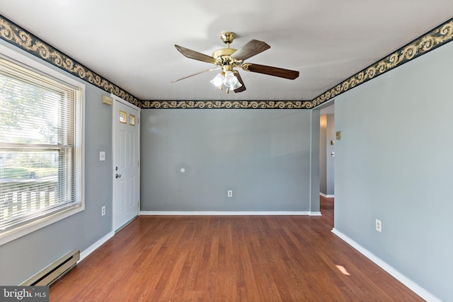 empty room featuring ceiling fan, dark hardwood / wood-style flooring, and baseboard heating