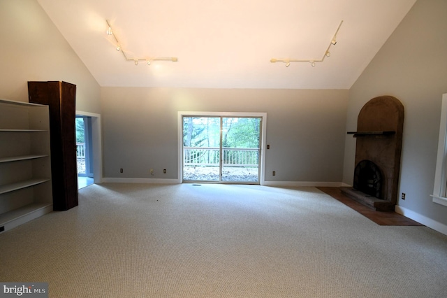 unfurnished living room featuring carpet floors, rail lighting, and high vaulted ceiling