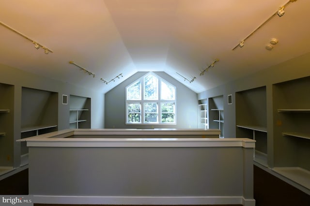 bonus room with built in features and vaulted ceiling