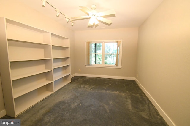 interior space featuring track lighting, dark colored carpet, and ceiling fan