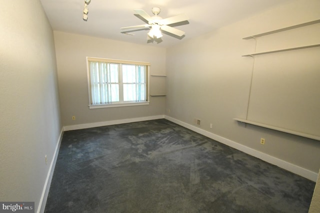 spare room with dark carpet and ceiling fan