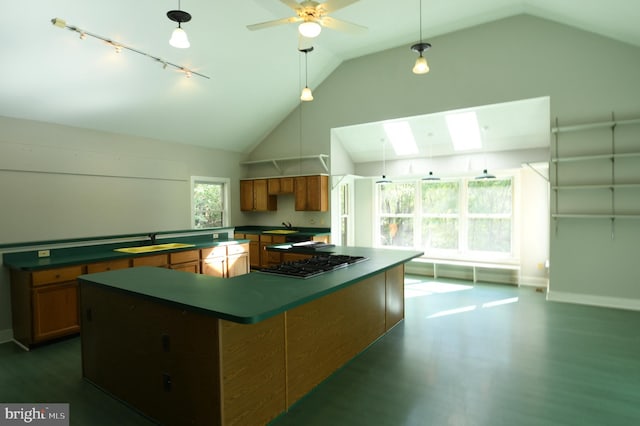 kitchen featuring a kitchen island, dark hardwood / wood-style floors, lofted ceiling with skylight, and stainless steel gas cooktop