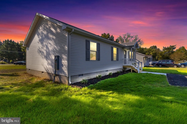 property exterior at dusk with a lawn