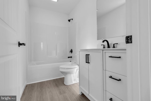 full bathroom with tub / shower combination, hardwood / wood-style floors, vanity, and toilet