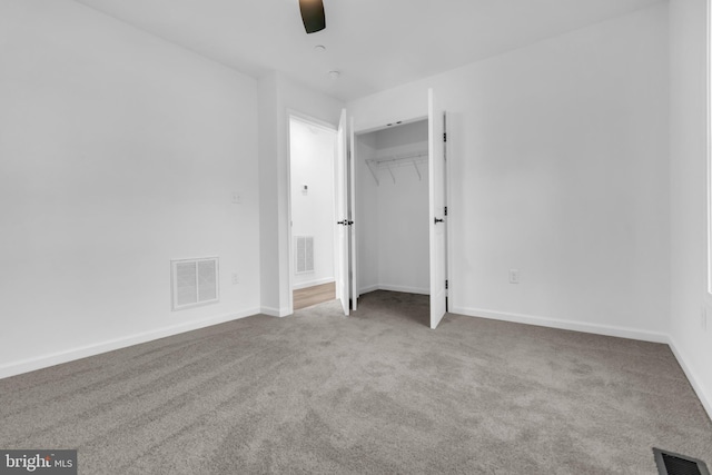 unfurnished bedroom featuring ceiling fan, a closet, and light carpet