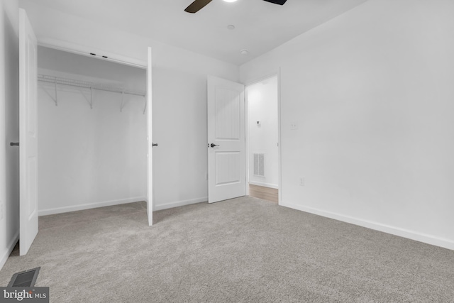 unfurnished bedroom featuring ceiling fan, a closet, and light carpet