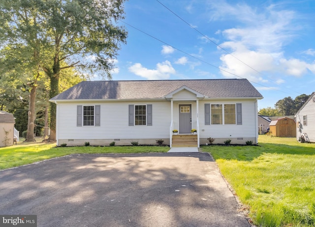 view of front of property with a front lawn and a storage unit