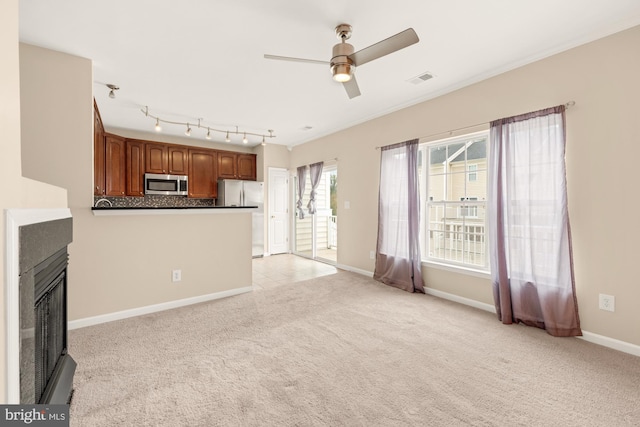 unfurnished living room with ceiling fan and light carpet