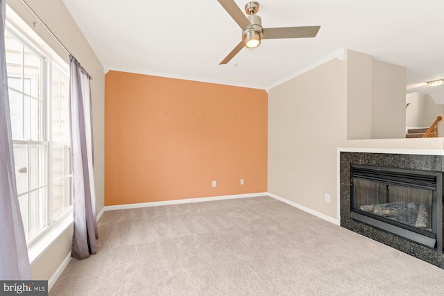 unfurnished living room with light colored carpet, crown molding, and a wealth of natural light