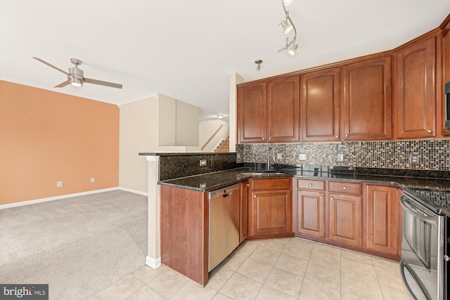 kitchen featuring dark stone countertops, appliances with stainless steel finishes, sink, and decorative backsplash