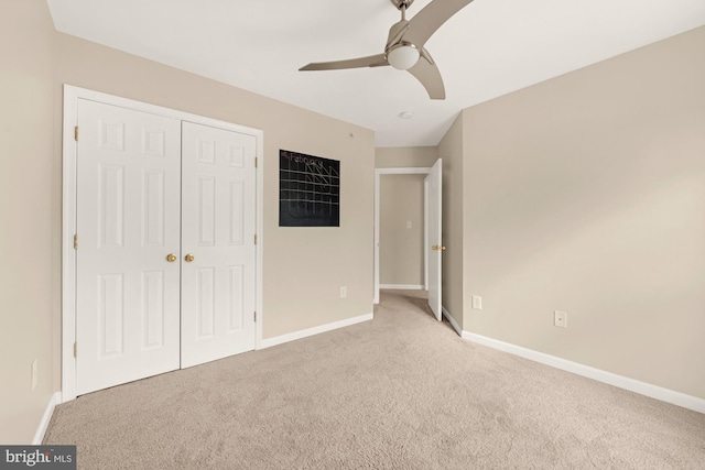 unfurnished bedroom featuring a closet, light colored carpet, and ceiling fan