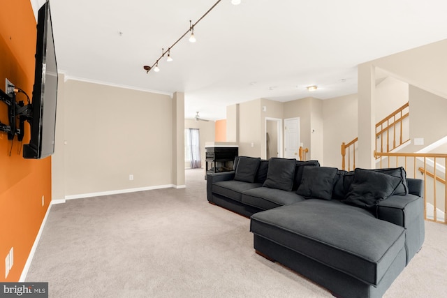 carpeted living room featuring ornamental molding and track lighting