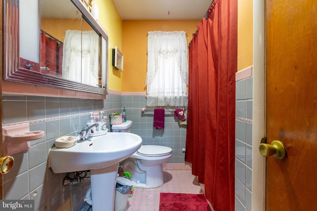 bathroom featuring tile walls and toilet