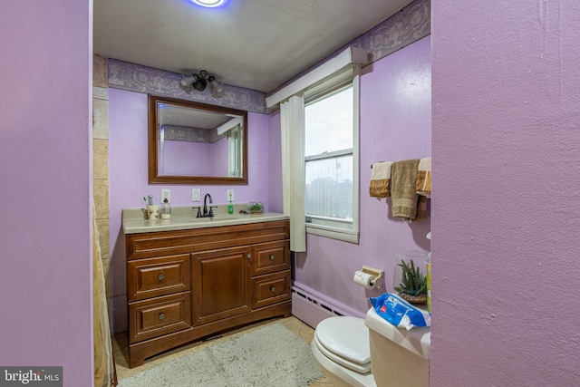 bathroom featuring vanity, toilet, and a baseboard heating unit