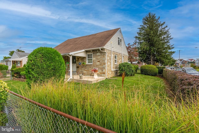 view of side of home with a patio and a lawn