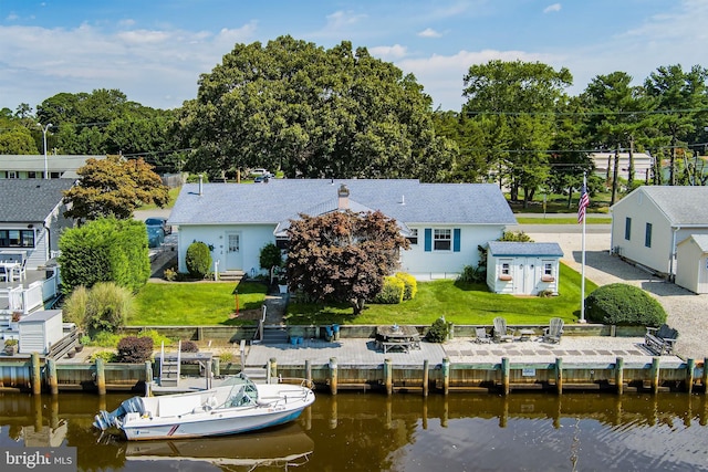 rear view of property with a lawn and a water view