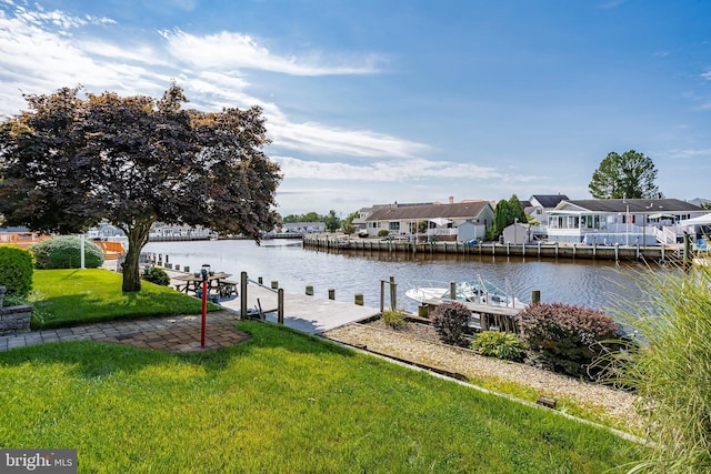 view of dock featuring a lawn and a water view