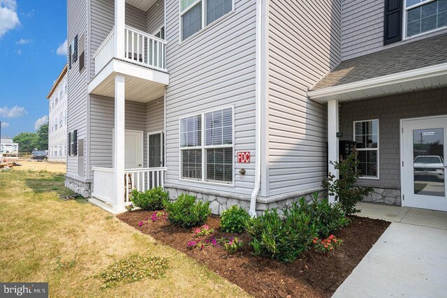 view of property exterior with a yard and a balcony