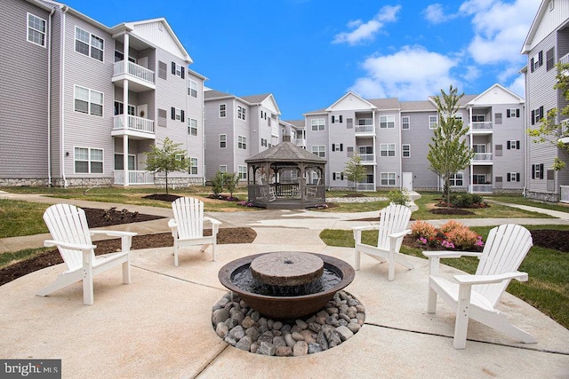 view of patio with a gazebo, an outdoor fire pit, and a balcony