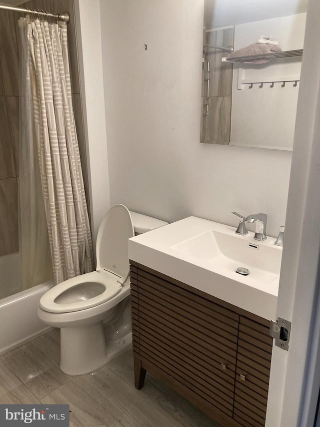 full bathroom featuring toilet, vanity, wood-type flooring, and shower / tub combo