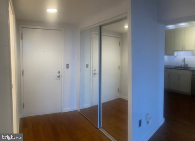 hall featuring dark wood-type flooring and sink