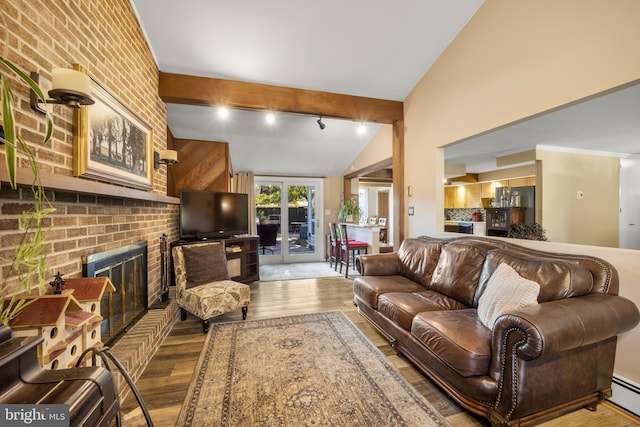 living room with french doors, vaulted ceiling with beams, light hardwood / wood-style flooring, brick wall, and a brick fireplace