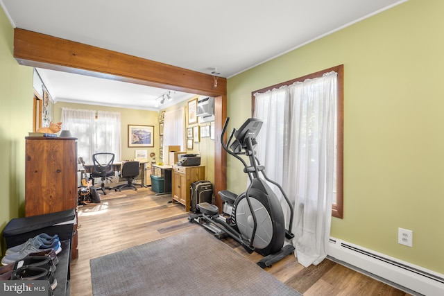 workout room with light hardwood / wood-style flooring, ornamental molding, and a baseboard radiator