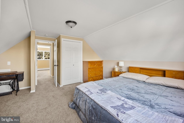 bedroom featuring baseboard heating, light colored carpet, and vaulted ceiling