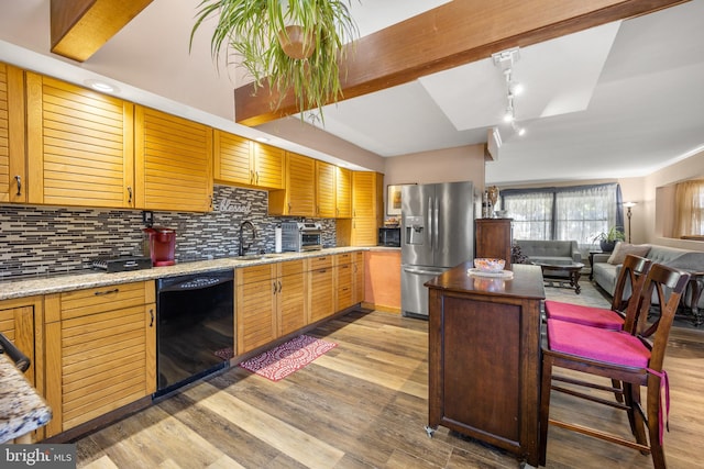 kitchen featuring stainless steel fridge, backsplash, light wood-type flooring, dishwasher, and sink