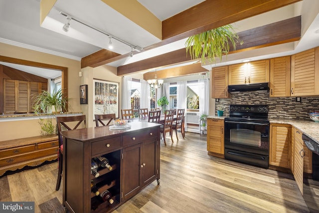 kitchen featuring tasteful backsplash, track lighting, black appliances, pendant lighting, and light hardwood / wood-style floors