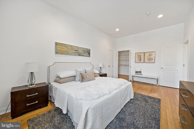 bedroom with a closet, recessed lighting, and light wood-type flooring