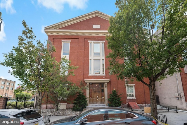 view of front of home with brick siding and fence