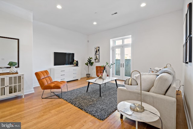 living area featuring french doors, baseboards, light wood-type flooring, and recessed lighting