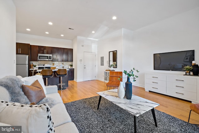 living room with electric panel and light hardwood / wood-style floors