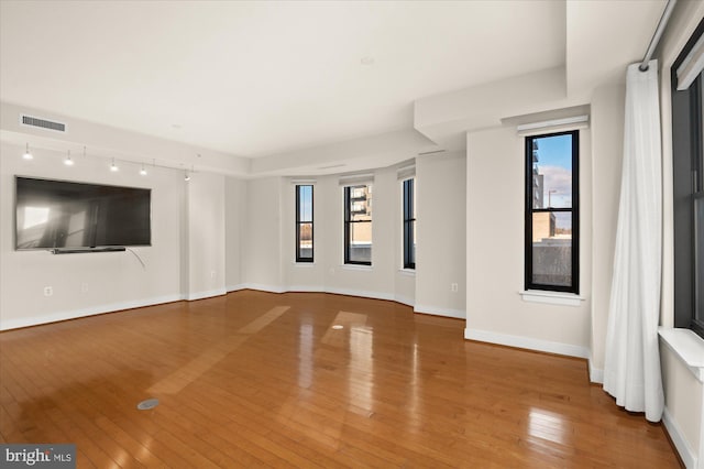 unfurnished living room with wood-type flooring and a healthy amount of sunlight