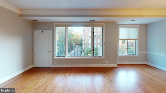 spare room with crown molding and light hardwood / wood-style flooring