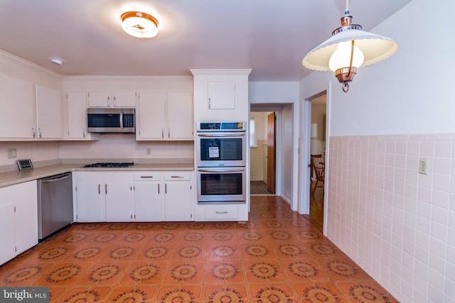 kitchen featuring white cabinetry, decorative light fixtures, and appliances with stainless steel finishes